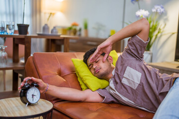 portrait of young sleeping muslim man in the bed turning the alarm off