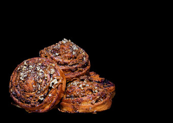 fresh delicious buns with nuts cream and poppy seeds on black background