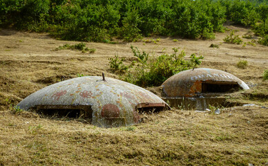 Two, old, Albanian bunkers inside ground.