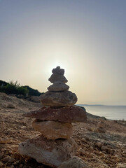 Stacked stones pyramide in the Algarve in Portugal. Sunrise in background.
