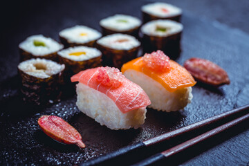 Assortment of vegan sushi with vegetables, seitan, Konjac plant, tofu as fish substitutes, with finger lime as caviar on black - obrazy, fototapety, plakaty