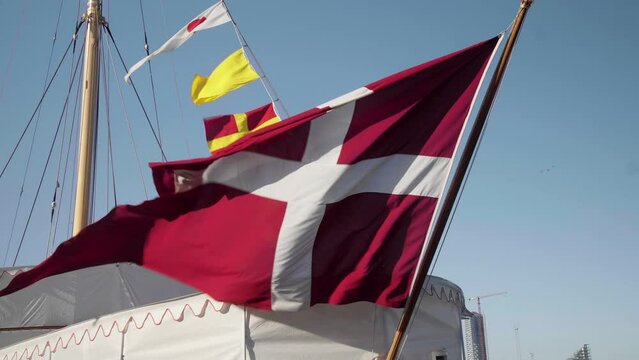 Denmark Flag Waving in the Wind  back of Royal Danish Yacht Close Up with blue sky  4k