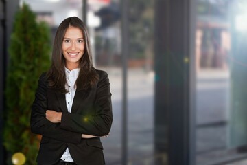 Happy attractive young businesswoman standing alone