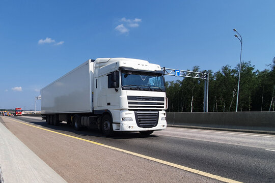 A white truck is moving along the autobahn. Freight, container transportation.