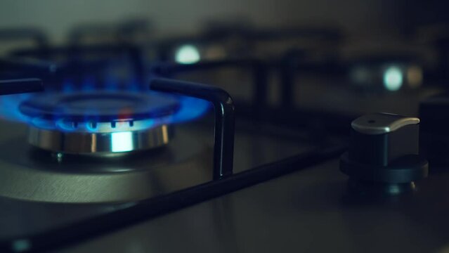 Three gas burners burn simultaneously on stove in dark. Circular gas-jet ignition. Embargoes and economic sanctions. Global crisis