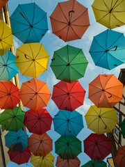 Fototapeta na wymiar Bunte Regenschirme über Straße in Altstadt