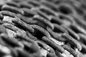 Monochrome image, chain links in row close up macro shot for background, space for text.