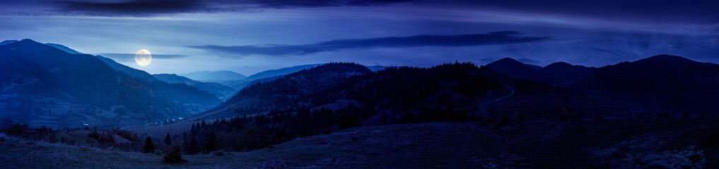 panorama of countryside landscape at night. grassy pasture meadows and forested hills in autumn....