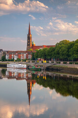 Bremen, Germany. Cityscape image of riverside Bremen, Germany with reflection of the St. Stephani Church in Weser River at summer sunrise.