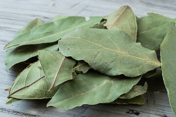 Dried whole bay leaves on cutting board (Laurus nobilis)