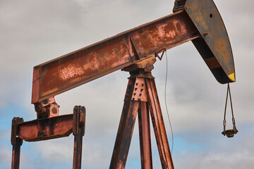 Rusty oil pumping machine. Pump jack. Petroleum extraction. Global warming