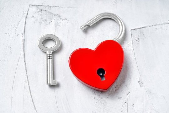 Red heart-shaped padlock with a key on gray - Powered by Adobe