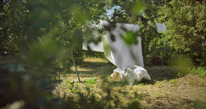 Hanging Laundry Bed Wet Sheets On Clothesline in Countryside in summer day. High quality 4k footage
