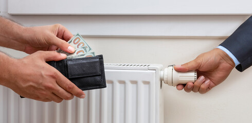 Hands hold wallet with money near the radiator. front view
