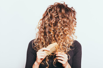 Woman combing her naturally curly hair