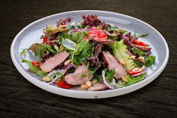 Josper-oven veal salad with sauce. On a dark background, isolated.