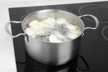 Cooking delicious dumplings in pot on cooktop