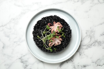 Delicious black risotto with seafood on white marble table, top view