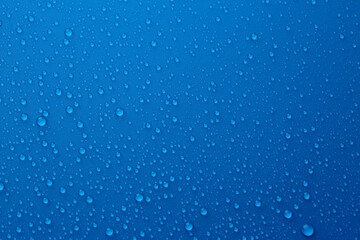 Naklejka na ściany i meble Water drops on blue background, top view