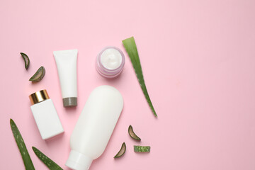 Flat lay composition with aloe vera and cosmetic products on pink background. Space for text
