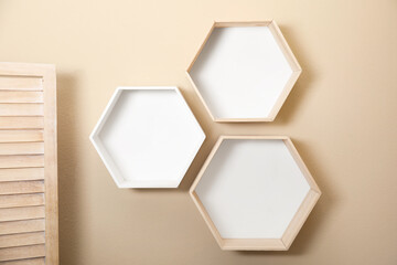 Empty honeycomb shaped shelves on beige wall