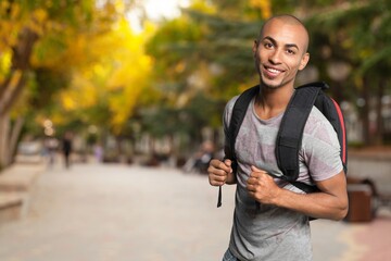 Smiling student walking outdoor in a college courtyard outdoor
