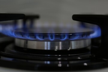 Modern kitchen stove with burning gas, closeup