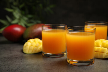Fresh delicious mango drink on grey table