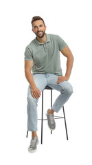 Handsome man sitting on stool against white background