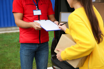 Courier receiving receipt signature from customer outdoors, closeup