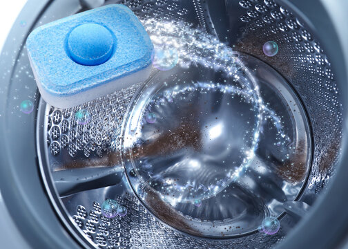 Water softener tablet in washing machine drum, closeup