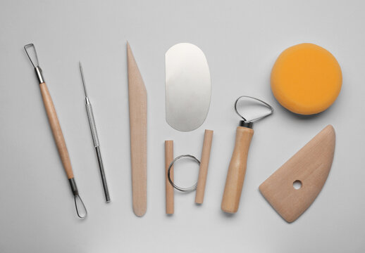 Set of clay modeling tools on white background, flat lay