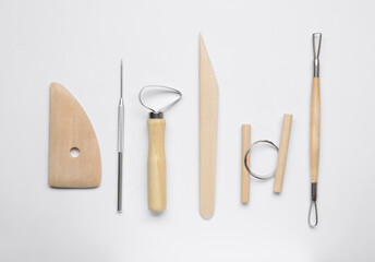 Set of clay modeling tools on white background, flat lay