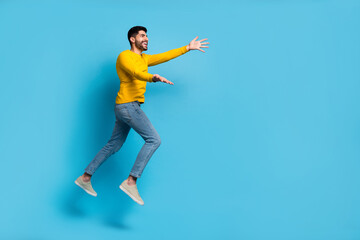 Full body profile photo of energetic satisfied person run jump raise opened hands empty space...