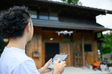 古民家の修繕をドローンでチェックする人　DX