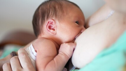 mother breastfeeds baby. newborn sucking a mother breast through a rubber nozzle. motherhood child...