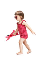 Little child girl walking holding a toy airplane in his hands isolated on white background. Travel and vacation concept.