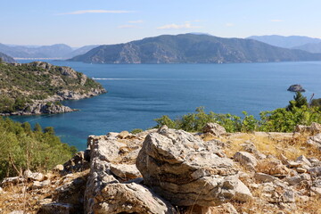 Fototapeta na wymiar Picturesque view to Mediterranean sea with rocky cliff, bays and islands. Summer coast of Turkey in Marmaris region with azure water and green mountains