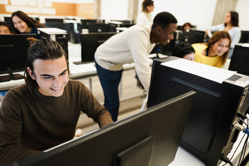 Young multiracial students using computers during business class at school - Focus on left guy face