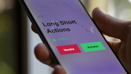 Un investisseur analyse un fonds etf long short actions sur un graphique. Un téléphone affiche le cours de l'ETF. Texte en français francais Long Short Actions