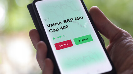 Un investisseur analyse un fonds etf valeur s&p mid cap 400 sur un graphique. Un téléphone affiche le cours de l'ETF. Texte en français francais Valeur S&P Mid Cap 400