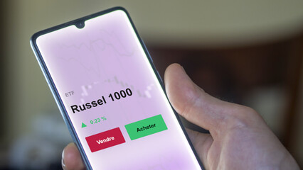 Un investisseur analyse un fonds etf russel 1000 sur un graphique. Un téléphone affiche le cours de l'ETF. Texte en français francais Russel 1000