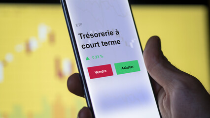 Un investisseur analyse un fonds etf trésorerie à court terme sur un graphique. Un téléphone affiche le cours de l'ETF. Texte en français francais Trésorerie à court terme