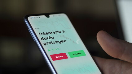 Un investisseur analyse un fonds etf trésorerie à durée prolongée sur un graphique. Un téléphone affiche le cours de l'ETF. Texte en français francais Trésorerie à durée prolongée