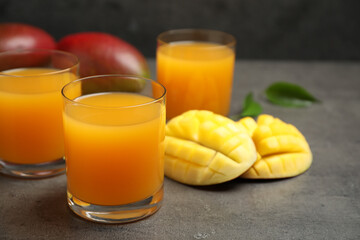 Fresh delicious mango drink on grey table