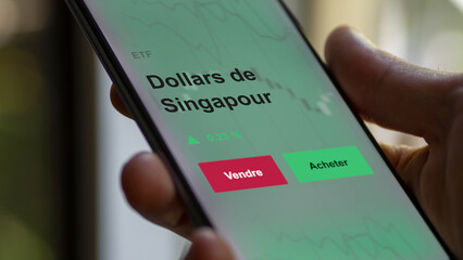 Un investisseur analyse un fonds etf dollars de singapour sur un graphique. Un téléphone affiche le cours de l'ETF. Texte en français francais dollars de Singapour