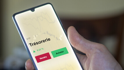 Un investisseur analyse un fonds etf trésorerie sur un graphique. Un téléphone affiche le cours de l'ETF. Texte en français francais Trésorerie