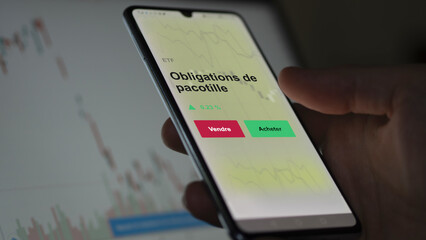 Un investisseur analyse un fonds etf obligations de pacotille sur un graphique. Un téléphone affiche le cours de l'ETF. Texte en français francais obligations de pacotille