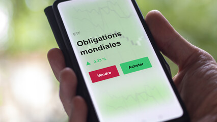 Un investisseur analyse un fonds etf obligations mondiales sur un graphique. Un téléphone affiche le cours de l'ETF. Texte en français francais Obligations mondiales