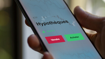 Un investisseur analyse un fonds etf hypothèques sur un graphique. Un téléphone affiche le cours de l'ETF. Texte en français francais Hypothèques